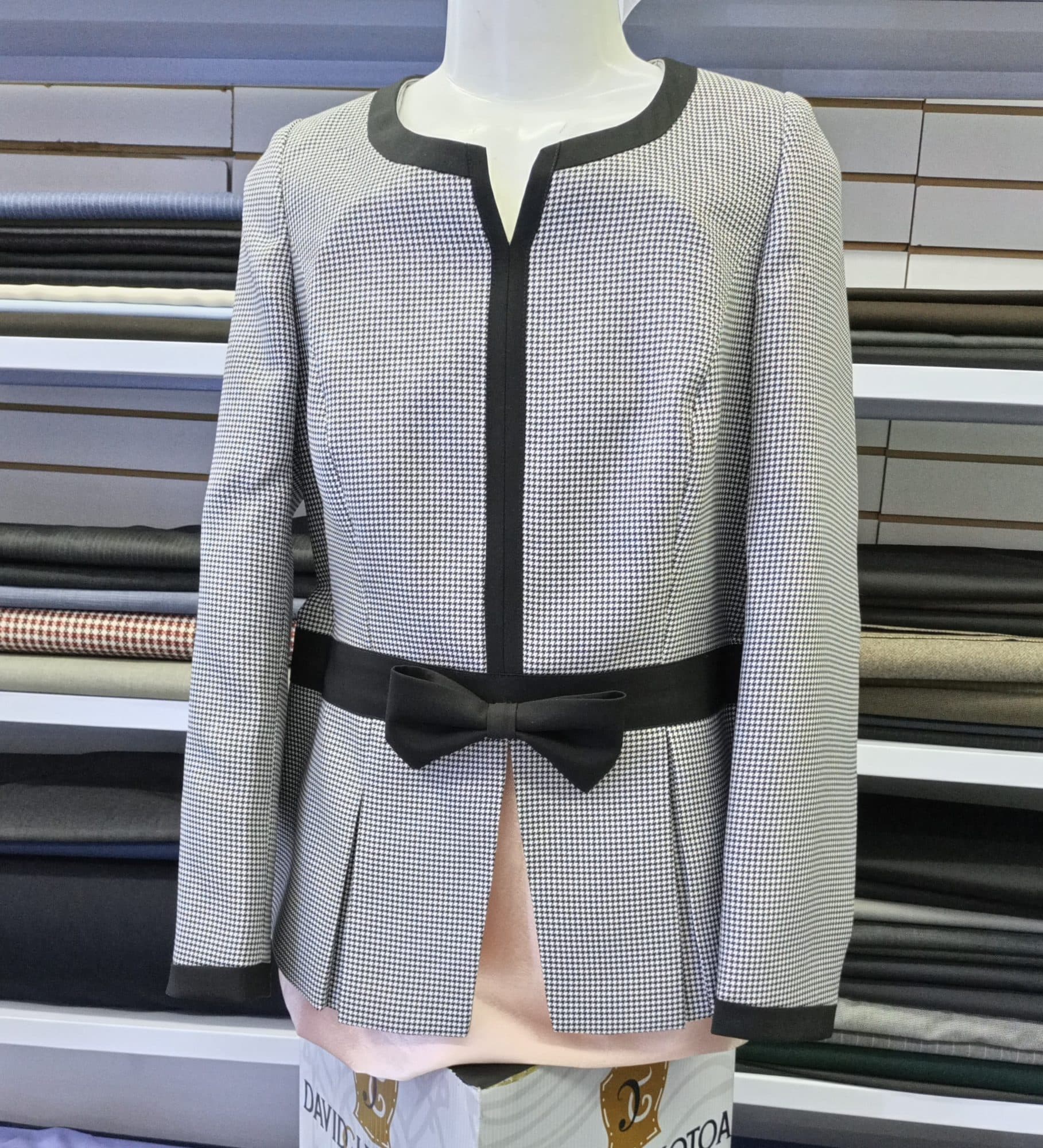 Chaqueta de dama gris con vivos negros y lazo